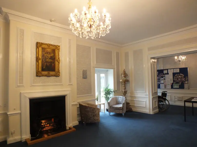 The elegant main lounge and fireplace at Lakenham Residential Care Home